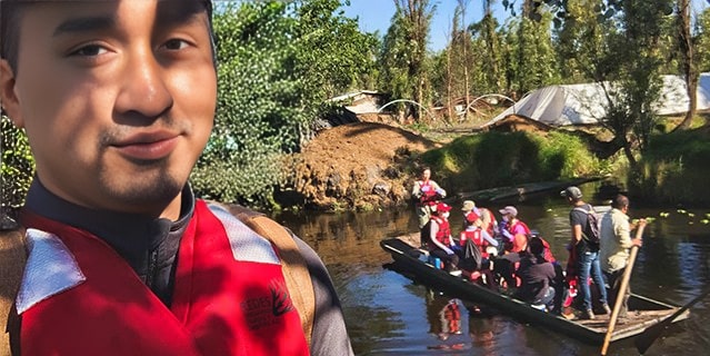 A young man with a group of young adults on a boat behind him in Mexico.