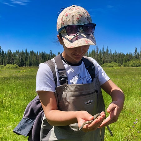 A Girls in Science fellow examining a snake.