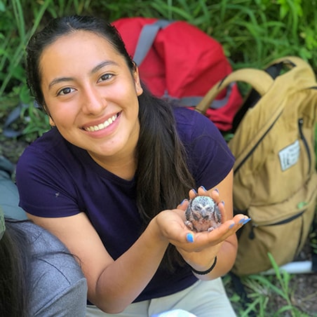 A teen girl holding an owl after weighing it in Utah.