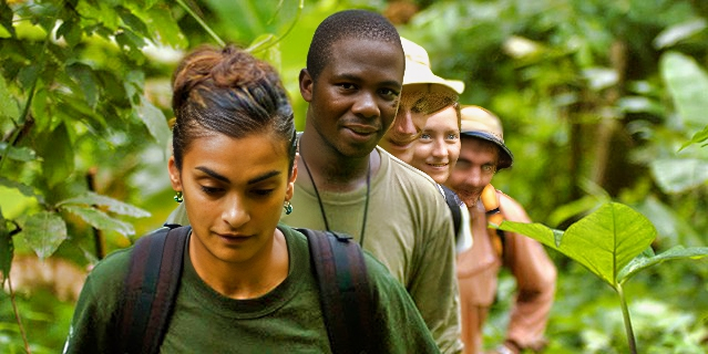 a group of five people hiking in the forest.