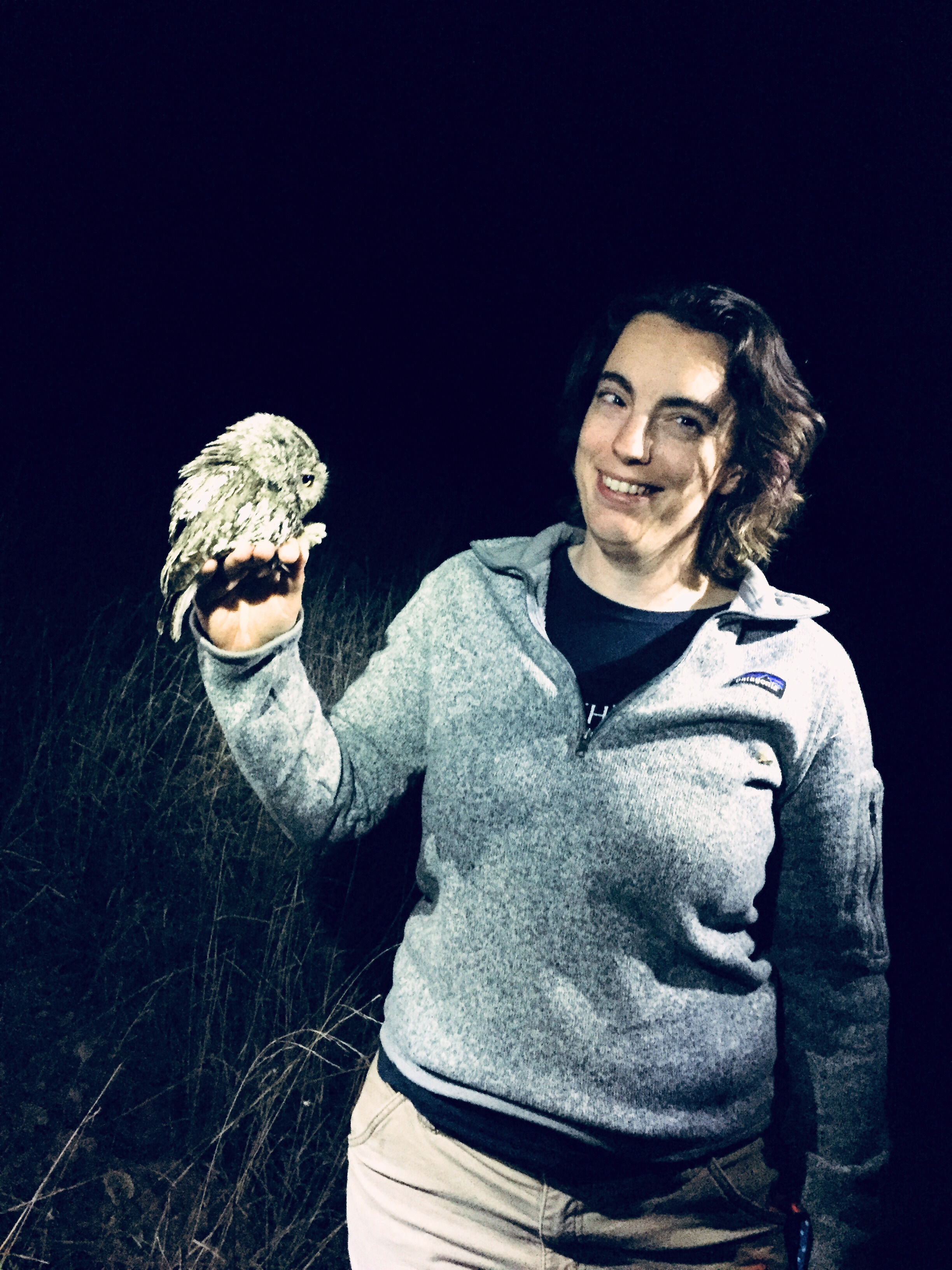 A person holding an owl smiling for a photo